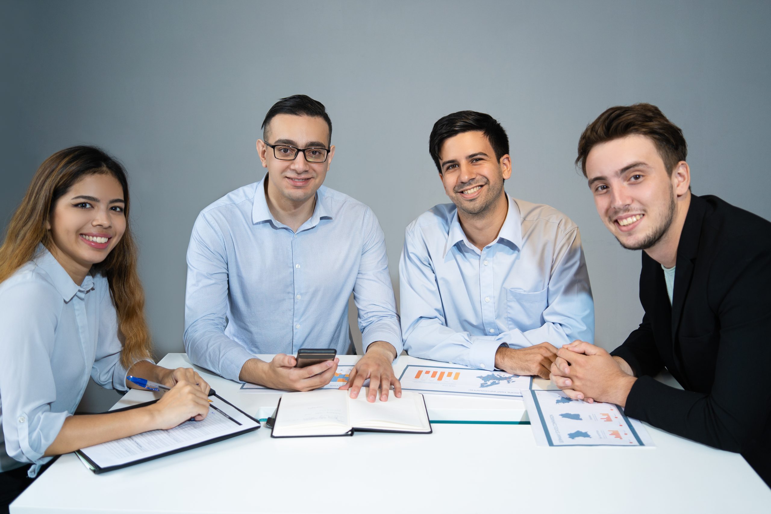 Portrait of happy business team sitting at table and smiling